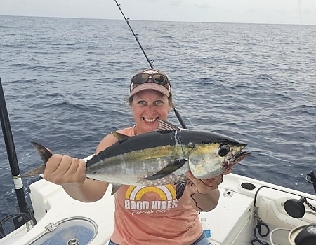 Woman holding a large fish on a boat during Key Largo fishing charters.