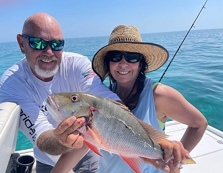 Man and woman holding a fish on a boat in Key Largo.