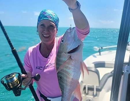 Woman holding a fish on a boat during Islamorada boat tours.