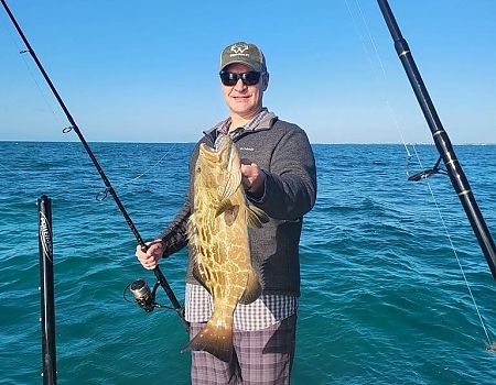 Man holding a fish on a boat in Islamorada during a private boat tour.