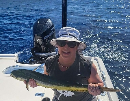 Woman holding a fish on a boat during a Key Largo fishing charters trip.