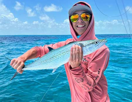 Young man holding a fish on a boat in Key Largo with Beyond Blessed Charters.