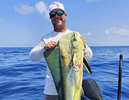 Man holding a large fish on a boat in Key Largo.