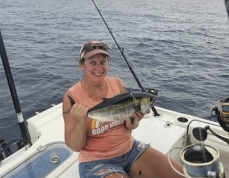 Woman holding a small fish on a boat in Islamorada.