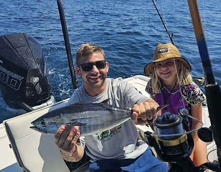Man and child holding a fish on a boat during Key Largo fishing charters.